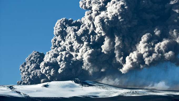 Vulkanismus und Gesellschaft schneebedeckter Berg mit riesiger Aschewolke