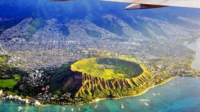 Vulkanismus und Gesellschaft Luftaufnahme Vulkankrater an Siedlung