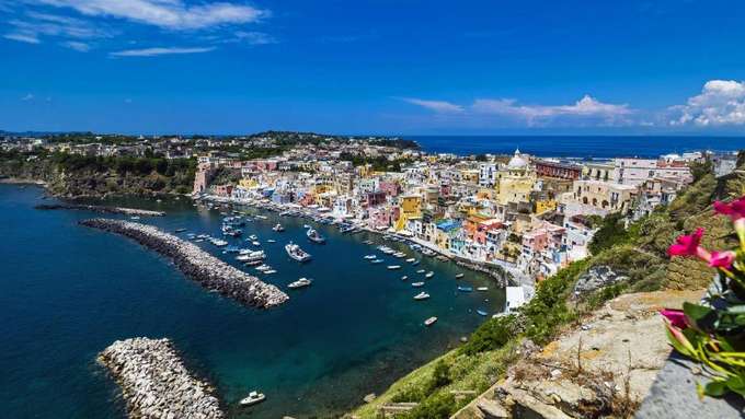 Vulkanismus Grundlagen Blick in Bucht mit bunten Häusern und kleinen Booten